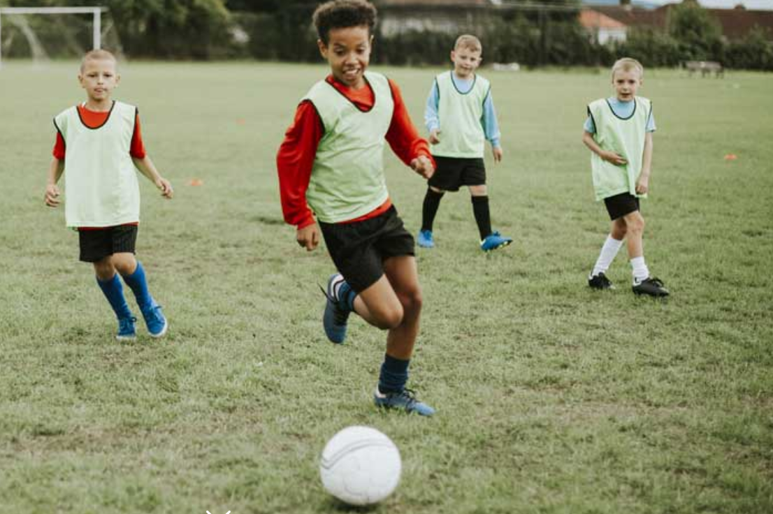 cropped-Soccer.png a group of kids playing football