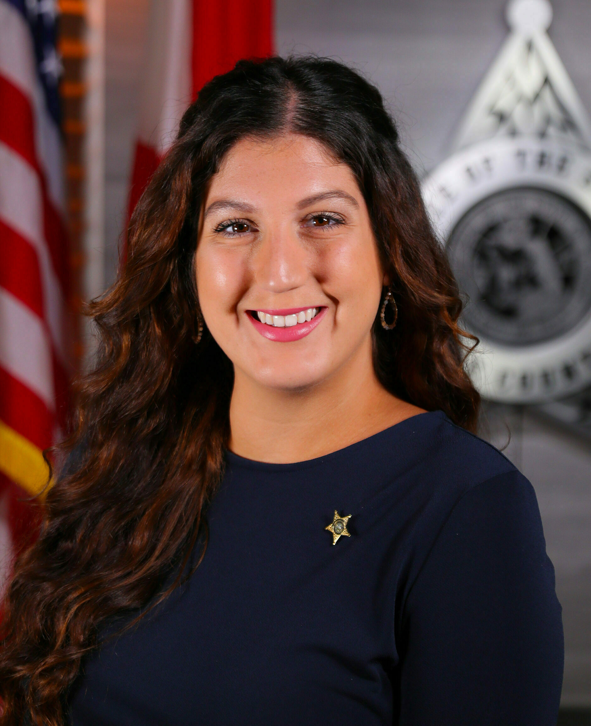 a woman smiling in front of flags